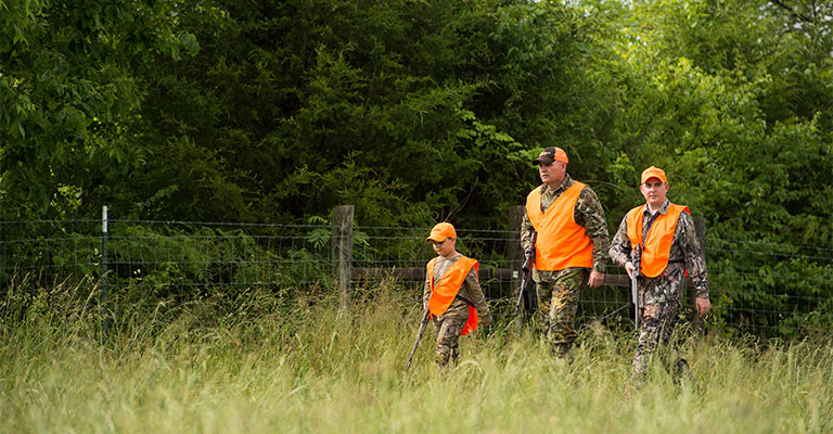 three hunters in field